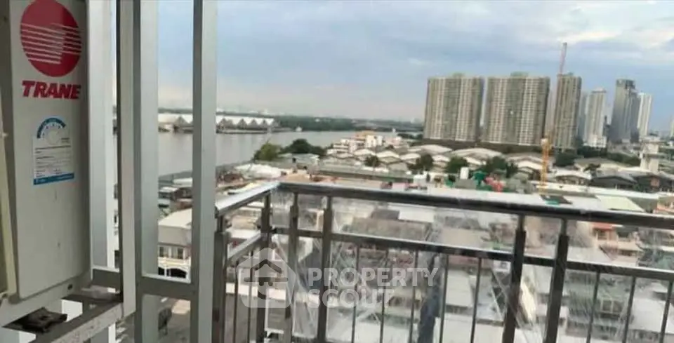 Stunning cityscape view from a high-rise balcony overlooking the river and urban skyline.