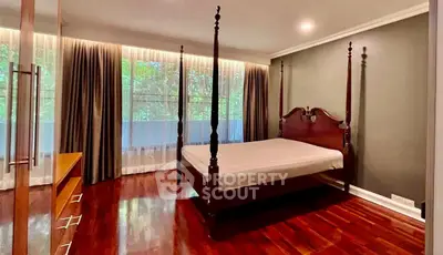 Spacious bedroom with elegant wooden flooring and large windows offering serene views.