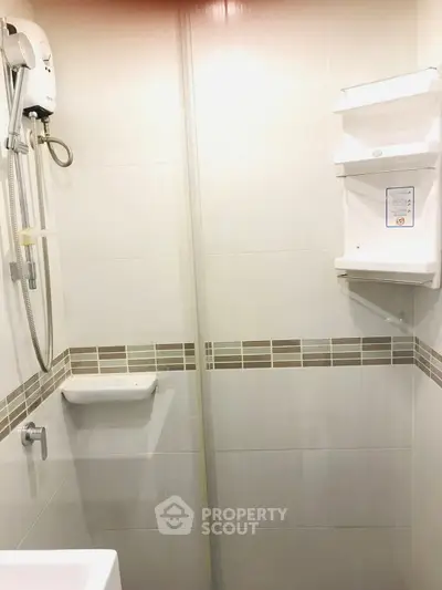 Compact bathroom with shower and tiled walls, ideal for modern living spaces.