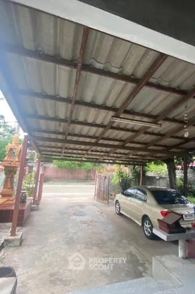 Spacious carport with metal roofing and parked car in residential area