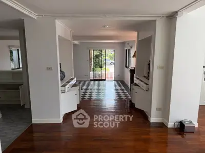 Spacious open-plan living area with hardwood floors and large windows for natural light.