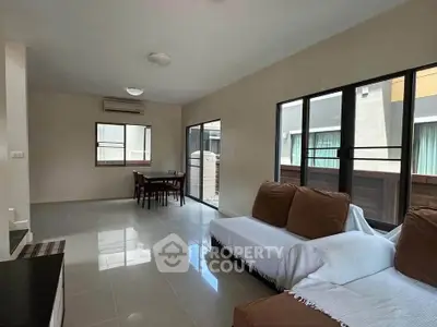 Spacious modern living room with large windows and cozy seating area