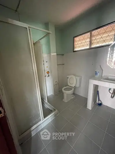 Spacious bathroom with shower and modern fixtures in a well-lit setting.