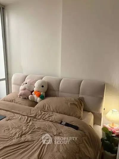 Cozy bedroom with plush headboard and soft lighting, perfect for relaxation.