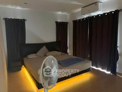 Cozy bedroom with ambient lighting and air conditioning, featuring dark curtains and a comfortable bed.