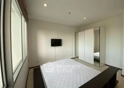 Spacious bedroom with large window and modern wardrobe