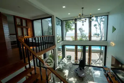 Luxurious living room with high ceilings, large windows, and pool view, perfect for relaxation and entertainment.