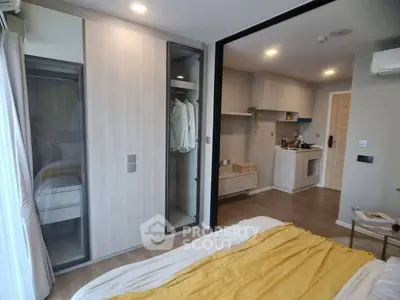 Modern studio apartment with open layout, featuring a cozy bedroom and compact kitchen area.