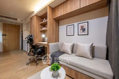 Modern living room with stylish decor and workspace, featuring wooden accents and cozy seating.
