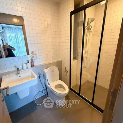 Modern bathroom with sleek shower and elegant fixtures in a contemporary home.