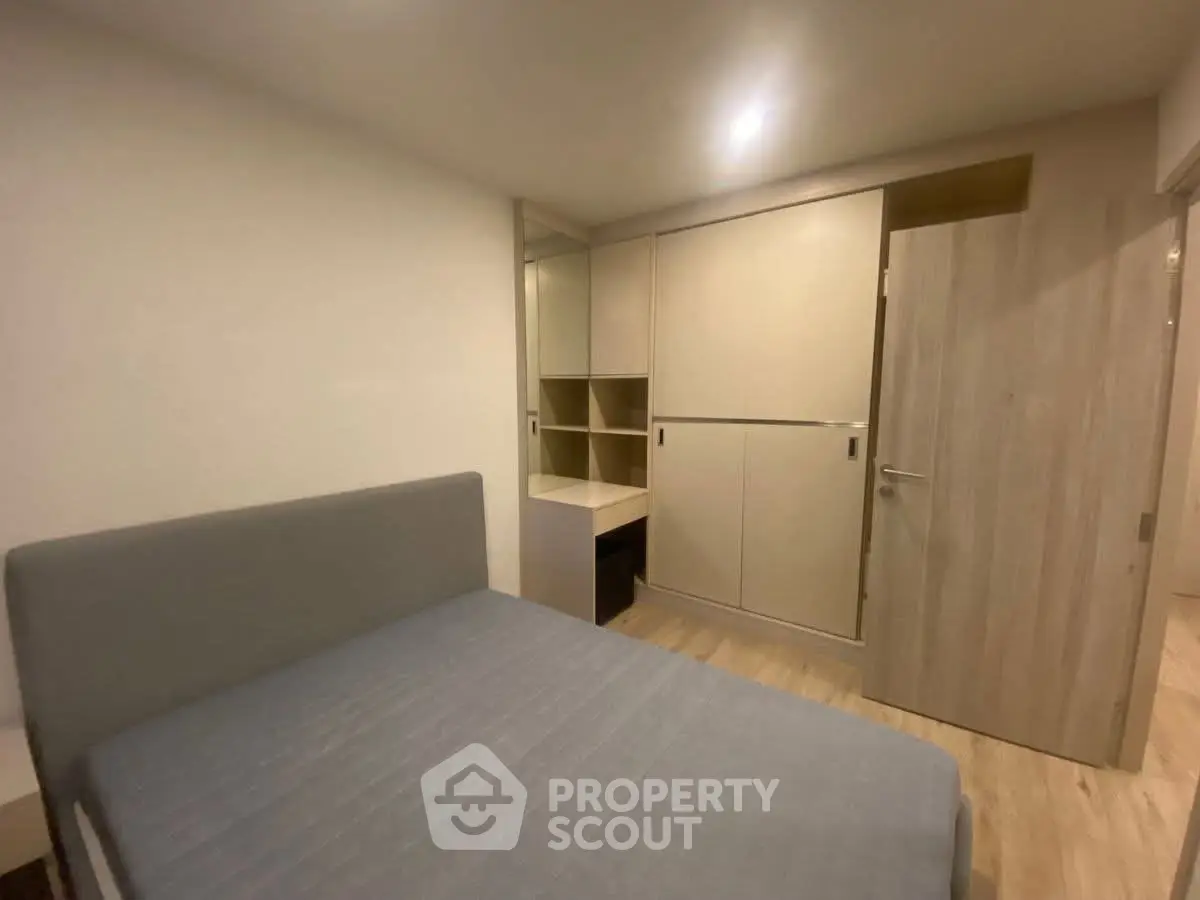 Modern bedroom with sleek built-in wardrobe and cozy bed in a minimalist design.