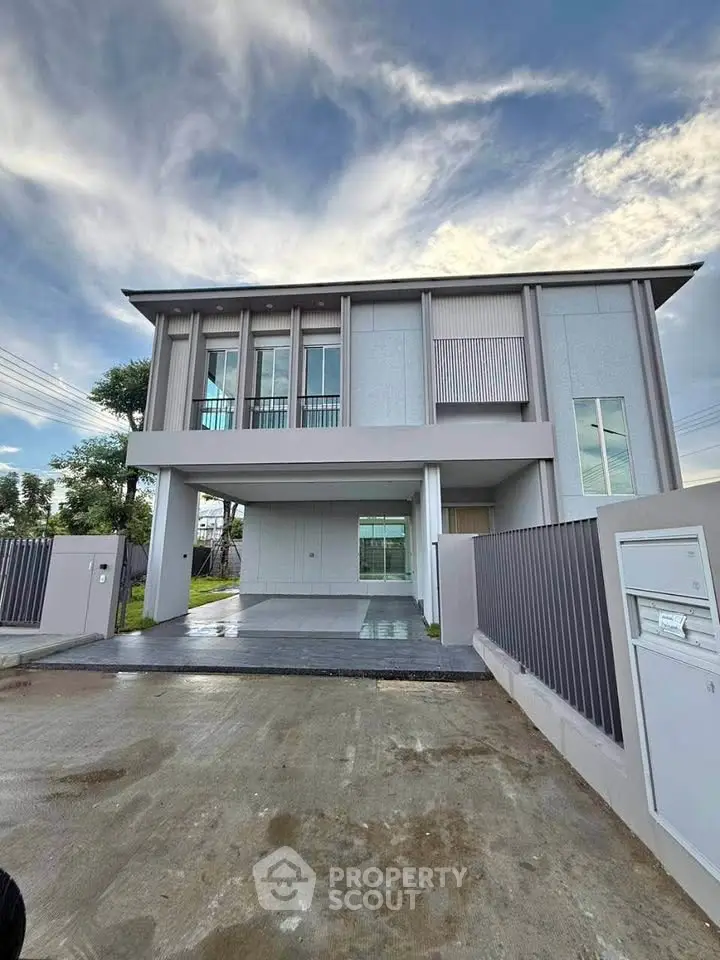 Modern two-story house with sleek design and spacious driveway in a serene neighborhood.