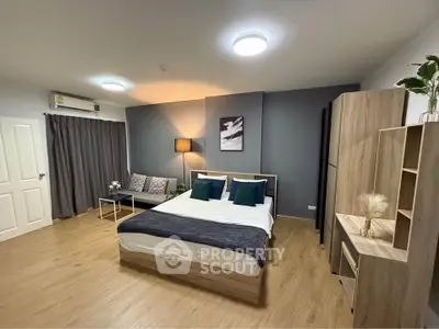 Spacious modern bedroom with stylish decor and cozy seating area