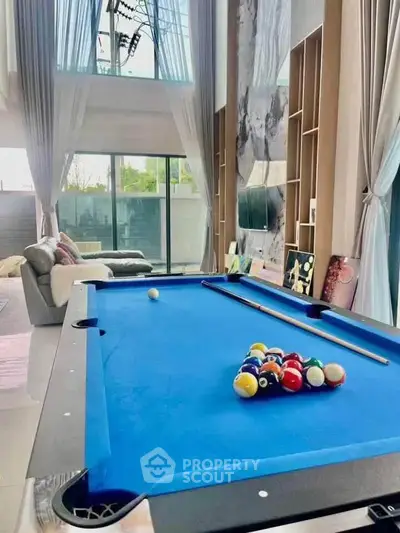 Luxurious living room with pool table and high ceilings, perfect for entertainment.