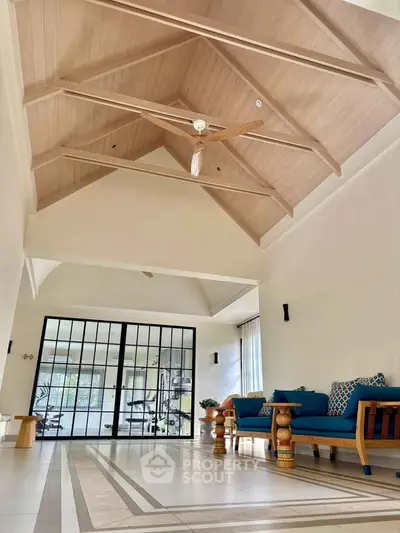 Spacious living room with high vaulted ceiling and stylish modern furniture.