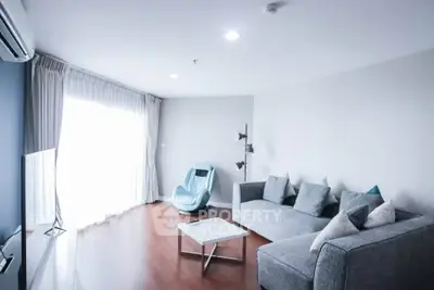 Spacious modern living room with stylish gray sofa and natural light