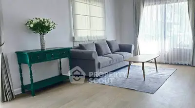 Elegant living room with gray sofa, stylish coffee table, and chic green console table.