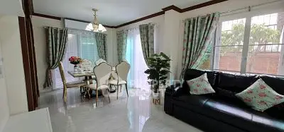 Elegant living room with dining area, featuring floral curtains and modern furniture.