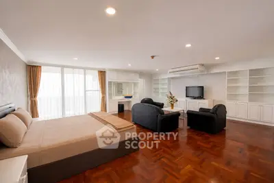 Spacious studio apartment with elegant wooden flooring and modern furnishings.