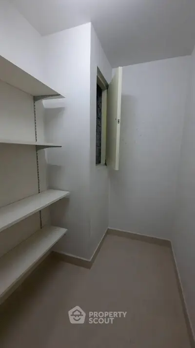 Spacious storage room with built-in shelves and natural light.