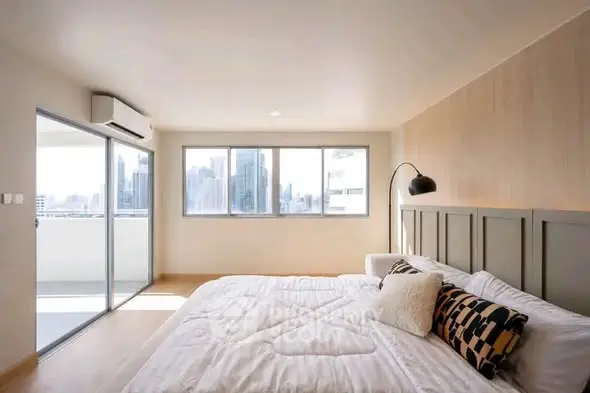 Spacious modern bedroom with city view and balcony access
