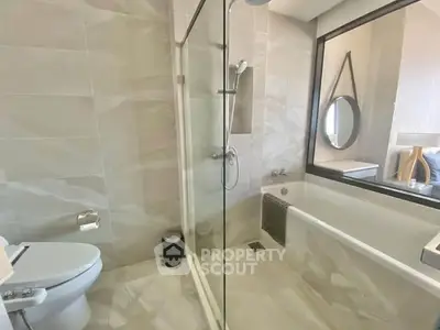 Modern bathroom with glass shower and bathtub in luxury apartment