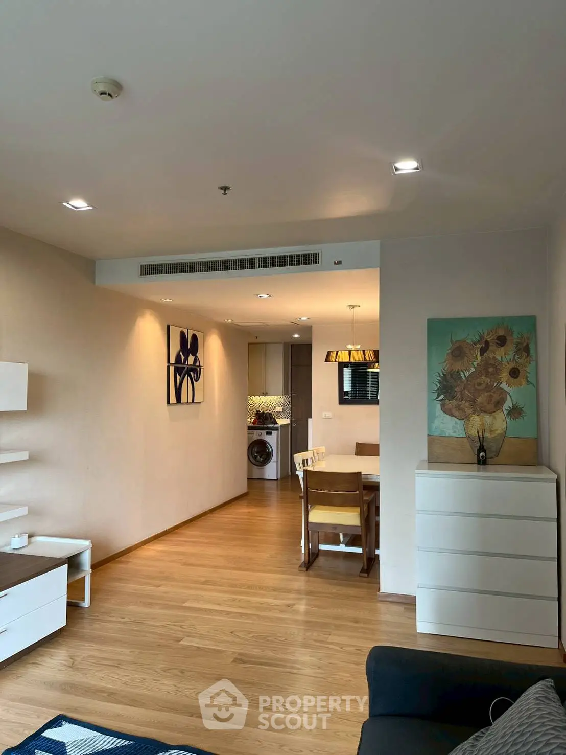 Modern living room with dining area and washing machine in open layout apartment