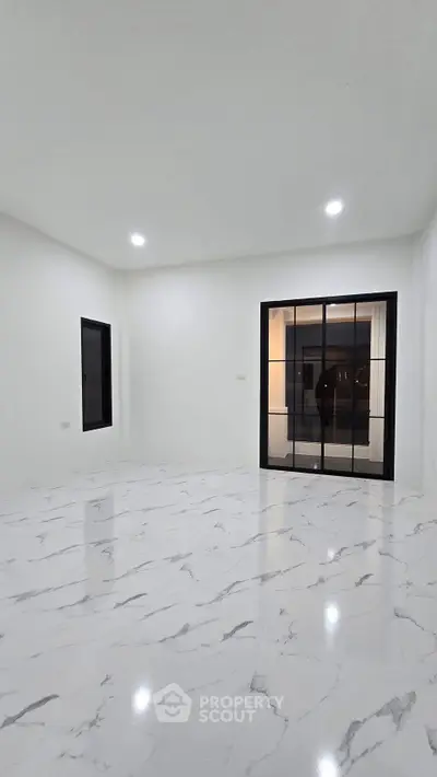 Spacious modern living room with marble flooring and large windows for natural light.