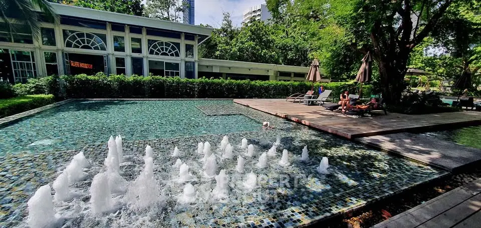 Luxurious outdoor pool area with fountains and lush greenery, perfect for relaxation and leisure.