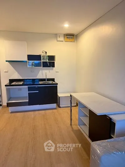 Modern compact kitchen with sleek cabinetry and open layout in a cozy apartment.