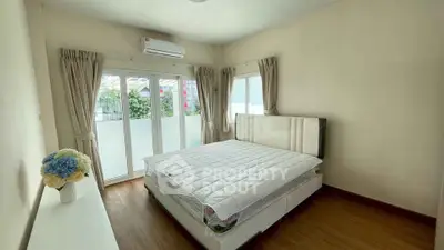 Bright and airy bedroom with large windows and modern decor, perfect for relaxation.