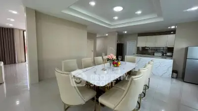 Luxurious dining area with elegant marble table and modern kitchen in open layout design.