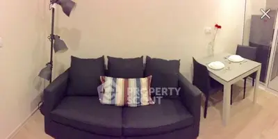 Cozy living room with modern sofa and dining area, perfect for urban living.