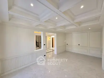 Elegant empty living room with coffered ceiling and marble flooring