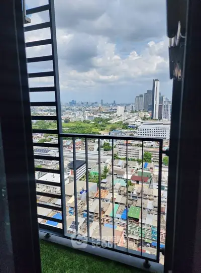 Stunning cityscape view from a high-rise balcony with lush greenery and urban skyline.