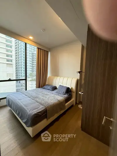 Modern bedroom with large window and city view in luxury apartment