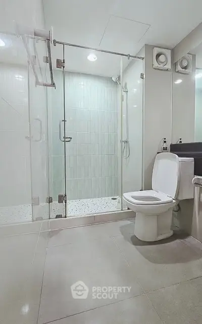 Modern bathroom with glass shower enclosure and sleek fixtures