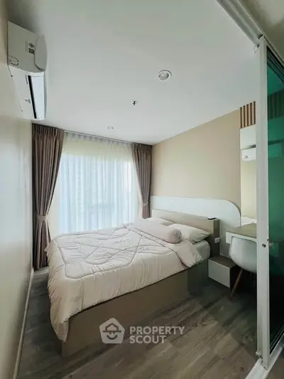 Modern bedroom with large window and stylish decor in a high-rise apartment.