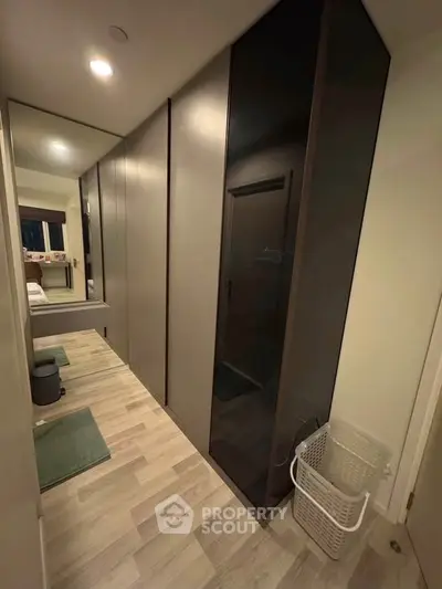 Modern bedroom with sleek wardrobe and cozy decor, perfect for urban living.