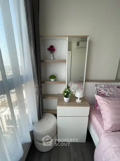 Chic bedroom corner with modern decor and city view, featuring elegant shelving and cozy seating.