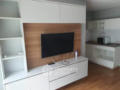 Modern living room with sleek TV unit and compact kitchen area