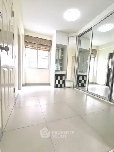Spacious room with mirrored closet and modern decor, perfect for stylish living.