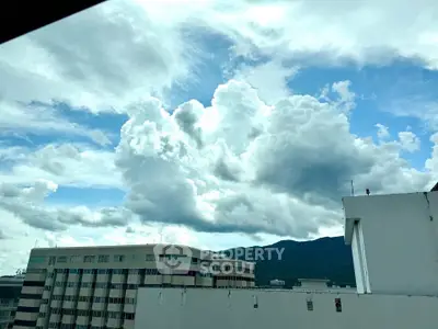 Stunning cityscape view with dramatic clouds over modern buildings.
