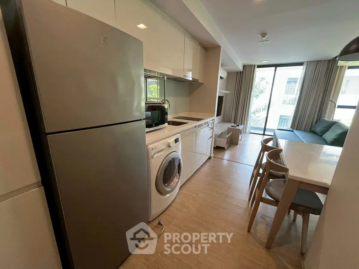 Modern open-layout kitchen and living area with natural light and sleek appliances.