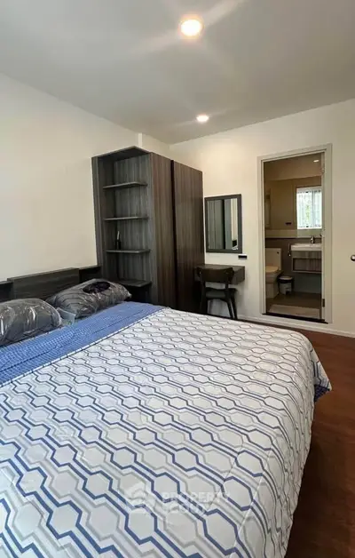 Spacious bedroom with modern furniture and ensuite bathroom in a stylish apartment.