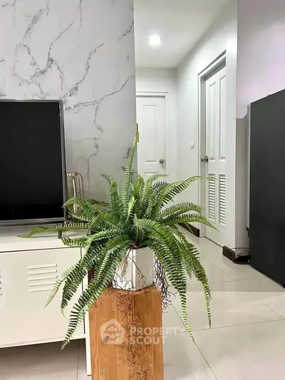 Modern living room with stylish decor and lush indoor plant enhancing the ambiance.