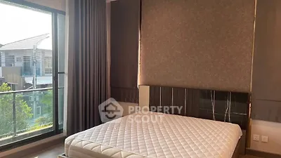 Modern bedroom with large window and stylish decor in a contemporary apartment.