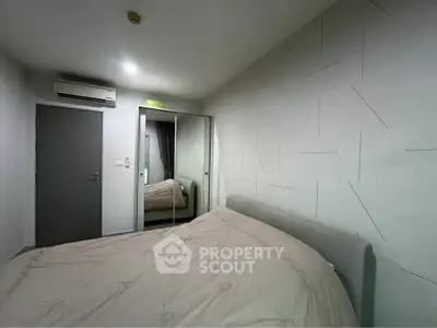 Cozy bedroom with mirrored wardrobe and modern air conditioning unit