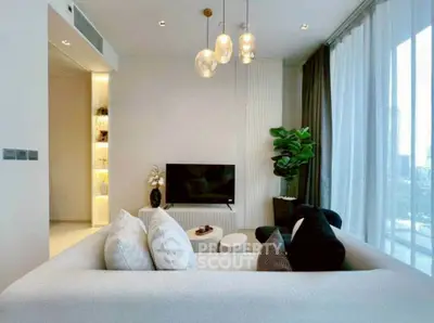 Modern living room with elegant decor and large windows offering city views.
