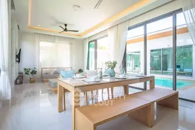 Stunning modern living room with pool view, featuring elegant dining setup and floor-to-ceiling windows.